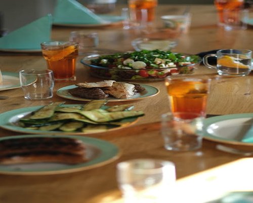 An evening dinner arrangement with lightly grilled poultry sliced zucchini and transparent water pitcher setting